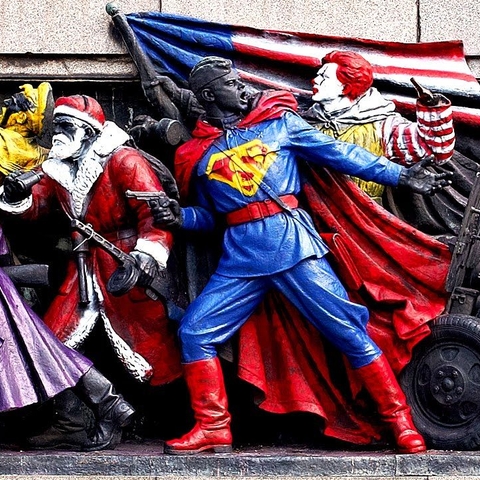Monument with figures dressed as pop culture figures like Superman, Santa, and Ronald McDonald