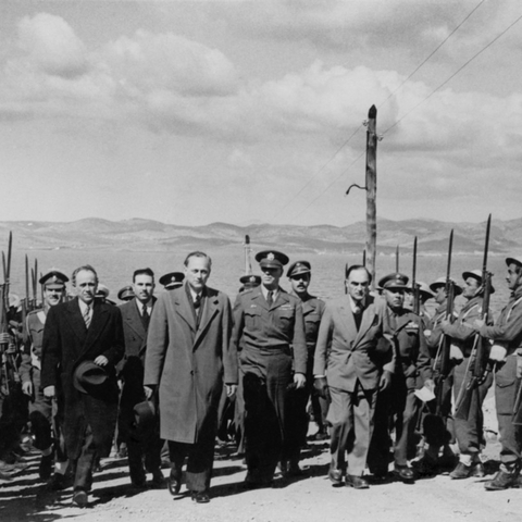 U.S. General James Van Fleet and Greek War Minister Kanellopoulos walking between lines of soldiers on the island of Makronissos during the Greek Civil War